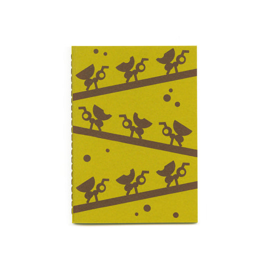 Green notebook with a brown illustration of ants carrying leafs on branches, brown stitched thread on the spine.