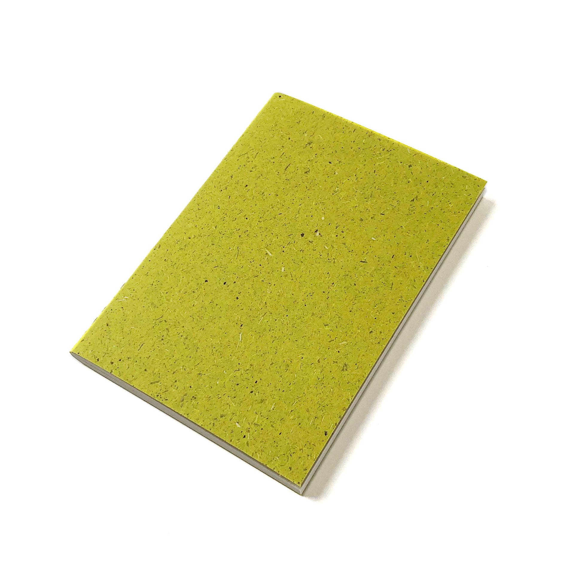 A green notebook with grass textured cover.