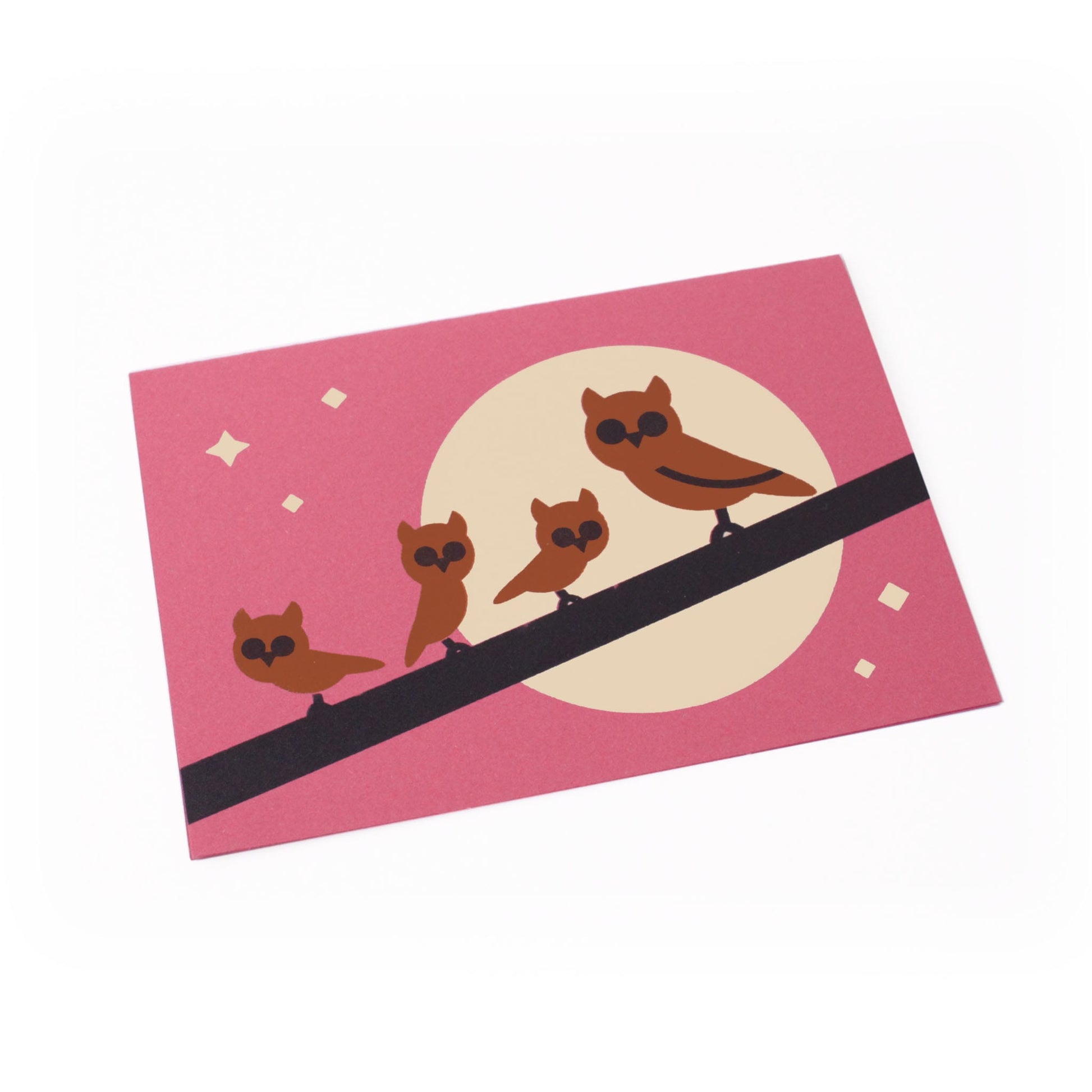 Greeting card with illustrated group of brown owls on a branch, set against a backdrop of moon and stars.
