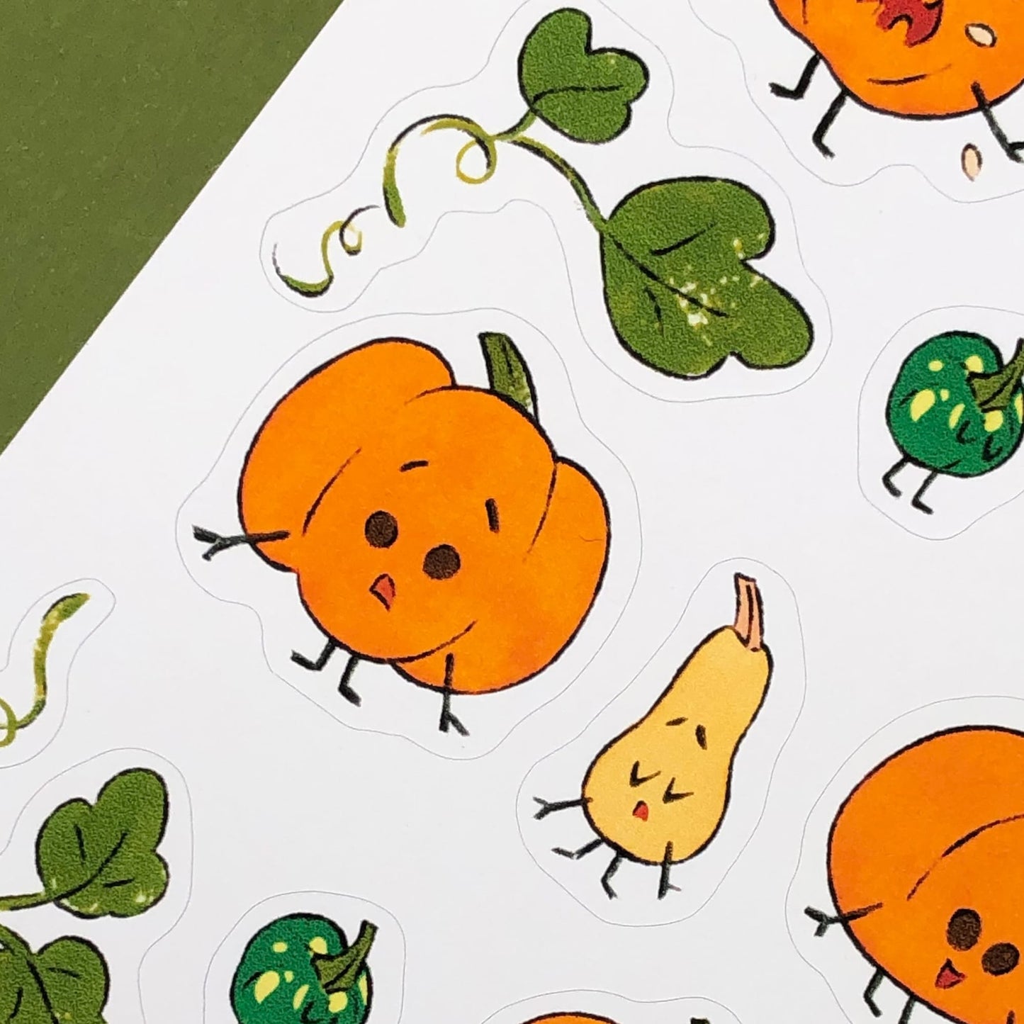 Illustrated pumpkins with expressions and leaves from a close view.