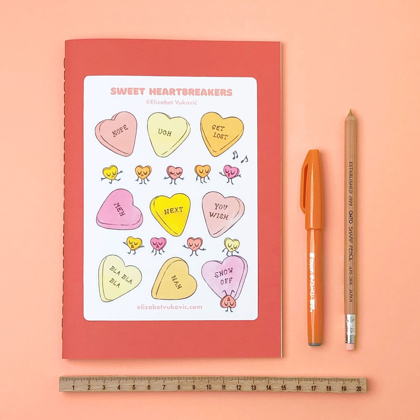 Sweet heartbreakers candy stickers beside pens and notebook.