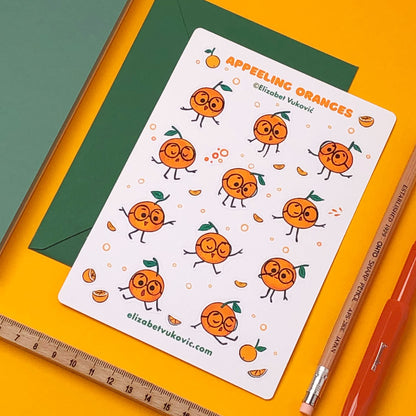 Appeeling Oranges Sticker sheet beside pens and journal.