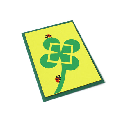 Greeting card with illustrated four leaf clover and ladybugs with an envelope.