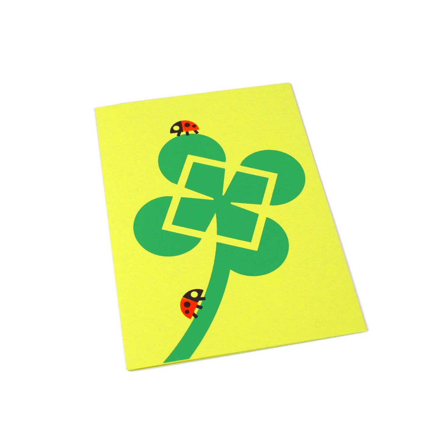 A green greeting card with an illustration of a clover and two ladybugs.