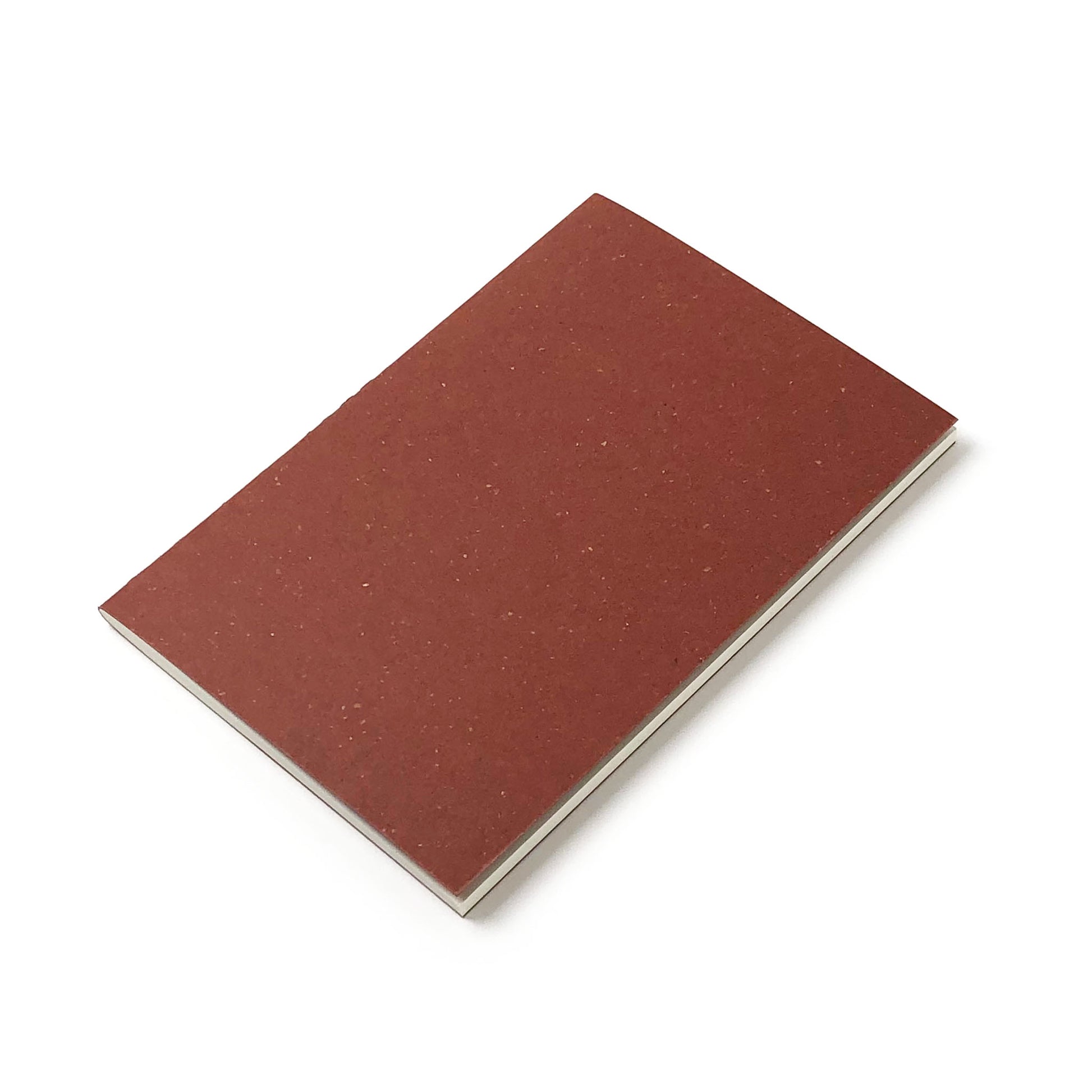 A tilted red-brown notebook with white pages inside against a white background.