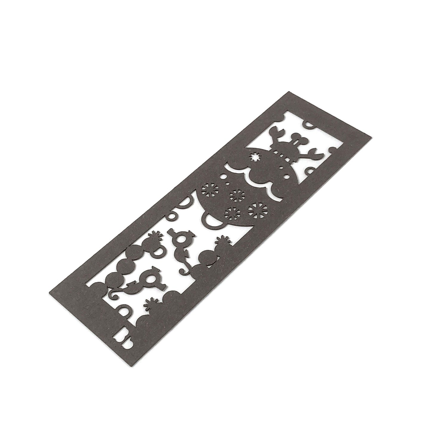 A tilted dark brown paper bookmark with a crab, seahorses, coral and bubbles cut-outs on a white background.