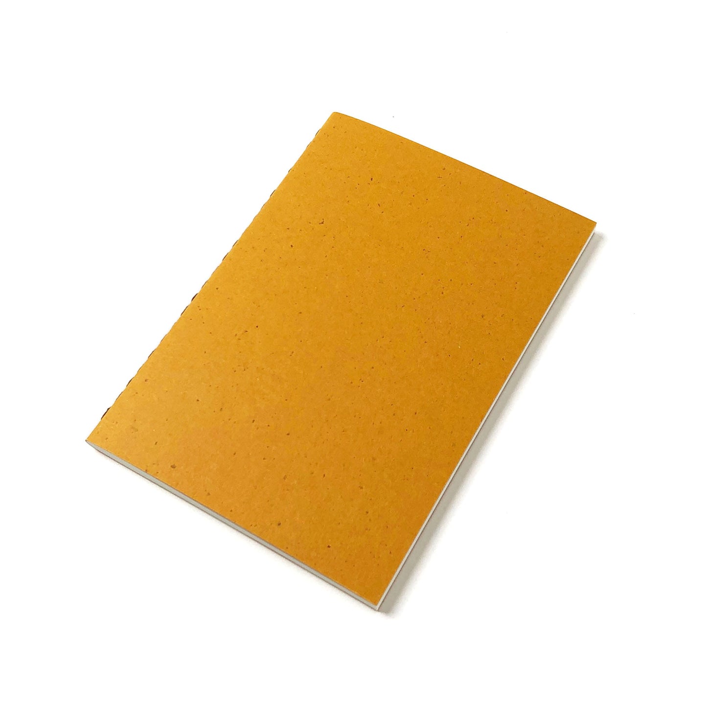 A yellow speckled notebook with a stitched spine and white pages lies on a white background.